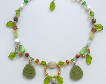 butterfly wing charm necklace with freshwater pearls, jade, tiger's eye, and goldstone beads