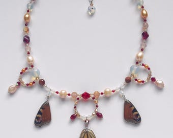 monarch butterfly wing charm necklace with freshwater pearls, opalite, and goldstone beads
