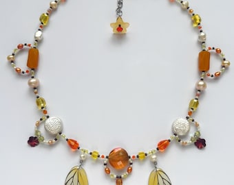 butterfly wing charm necklace with freshwater pearls, faceted glass and seed beads
