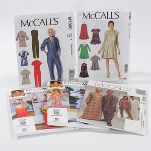 May include: Several McCall's sewing pattern envelopes are displayed. The patterns feature images of dresses, jumpsuits, and other garments. The envelopes are white with colorful illustrations and text. The patterns are for various sizes.
