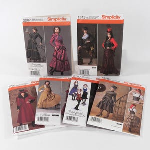 May include: A collection of six Simplicity sewing pattern envelopes featuring various garment designs. Each envelope displays photographs of models wearing the finished clothing items, along with the Simplicity logo, pattern numbers, and barcodes.