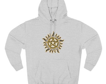 May include: A light gray hoodie featuring a large, stylized sun design with a five-pointed star in the center. The sun has a gold and black color scheme, with a detailed, textured appearance. The hoodie has a front pocket and a drawstring hood.