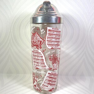 Puede incluir: Coctelera vintage con tapa de acero inoxidable y cuerpo de vidrio transparente. El vidrio est&aacute; decorado con ilustraciones y texto en rojo, incluidas recetas de c&oacute;cteles. La coctelera est&aacute; dise&ntilde;ada para mezclar bebidas.