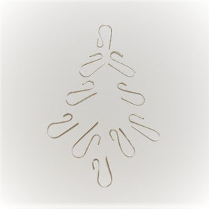 May include: A silver Christmas tree made from a collection of S-shaped hooks.