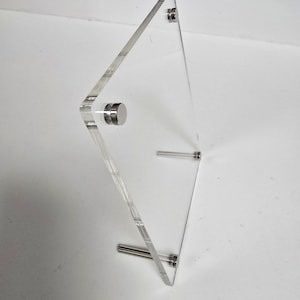 May include: A clear acrylic picture frame with silver metal stand and four silver metal fasteners.