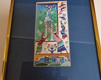 May include: A framed artwork depicting a colorful scene with two figures reaching up towards a glowing orb. The artwork is set against a blue background and features Hebrew text and a cityscape.