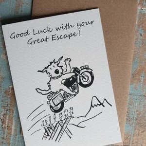 May include: A black and white illustration of a dog riding a motorbike over a fence. The card reads "Good Luck with your Great Escape!"
