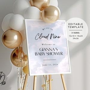 May include: A white sign with a blue and white cloudy background. The sign reads "We are on Cloud Nine. Welcome to Gianna's Baby Shower. June 11, 2024". The sign is on a wooden easel. The sign is surrounded by white and gold balloons.
