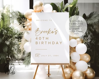 May include: A white sign with gold text that says "Welcome to Brooke's 40th Birthday Est. July 27, 1984". The sign is on a wooden easel and surrounded by white and gold balloons.