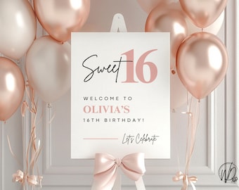 May include: A Sweet 16 birthday sign with the text "Sweet 16" in black script and pink numbers. The sign reads "Welcome to Olivia's 16th Birthday!" and "Let's Celebrate". The sign is surrounded by pink and white balloons.