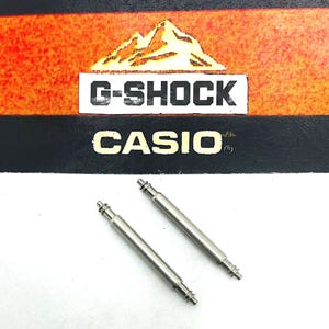 May include: Two silver watch band spring bars. The spring bars are about 2 inches long.