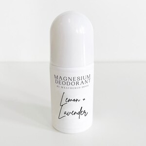 Pode incluir: Frasco de desodorizante roll-on branco com texto preto que diz "Magnesium Deodorant by Weathered Door Lemon + Lavender".