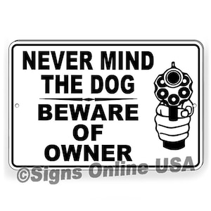 May include: Black and white sign with the text "Never mind the dog beware of owner" and a cartoon image of a hand holding a revolver.