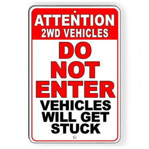 May include: Red and white sign with the text "ATTENTION 2WD VEHICLES DO NOT ENTER VEHICLES WILL GET STUCK".