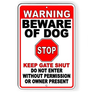 May include: White warning sign with red border and red stop sign. Text reads: "WARNING BEWARE OF DOG STOP KEEP GATE SHUT DO NOT ENTER WITHOUT PERMISSION OR OWNER PRESENT"