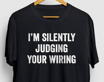 May include: Black t-shirt with white text that reads "I'm silently judging your wiring".