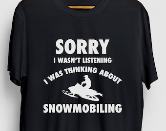 Puede incluir: Camiseta negra con texto blanco que dice "Lo siento, no estaba escuchando, estaba pensando en el esquí de fondo" y una silueta de una persona en una moto de nieve.