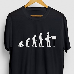 May include: Black t-shirt with a white graphic of the evolution of man, ending with a person checking their mailbox.