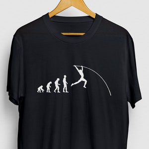Puede incluir: Camiseta negra con un gráfico blanco de la evolución de los humanos que culmina con un saltador con pértiga. El gráfico muestra una serie de figuras de palo que progresan desde un simio agachado hasta un humano moderno, terminando con una persona que supera un salto con pértiga.