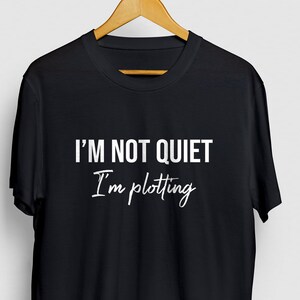 Puede incluir: Camiseta negra con texto blanco que dice "No estoy callado, estoy tramando".