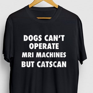 May include: Black t-shirt with white text that reads "Dogs can't operate MRI machines but catscan."