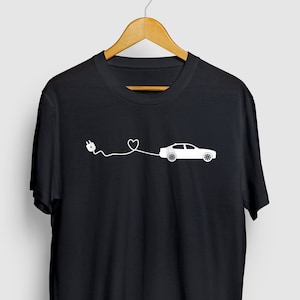 May include: Black t-shirt with a white graphic of an electric car connected to a plug with a heart in the cord.