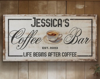 May include: A white wooden sign with black text that reads "Jessica's Coffee Bar Est. 2023 Life Begins After Coffee". A small illustration of a cup of coffee is in the centre of the sign.