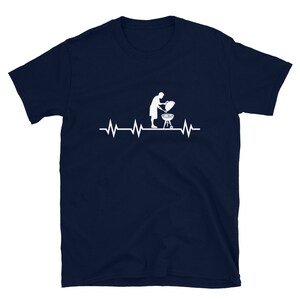 May include: A navy blue t-shirt with a white silhouette of a person grilling and a heartbeat graphic.