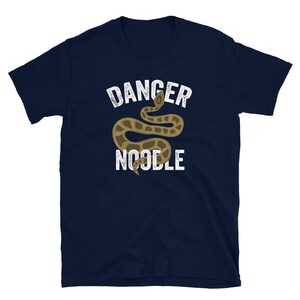 K&ouml;nnte beinhalten: Ein marineblaues T-Shirt mit einer wei&szlig;en Grafik einer Schlange und dem Text "Danger Noodle".