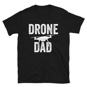 May include: Black t-shirt with white text that reads "Drone Dad" and a white silhouette of a drone.