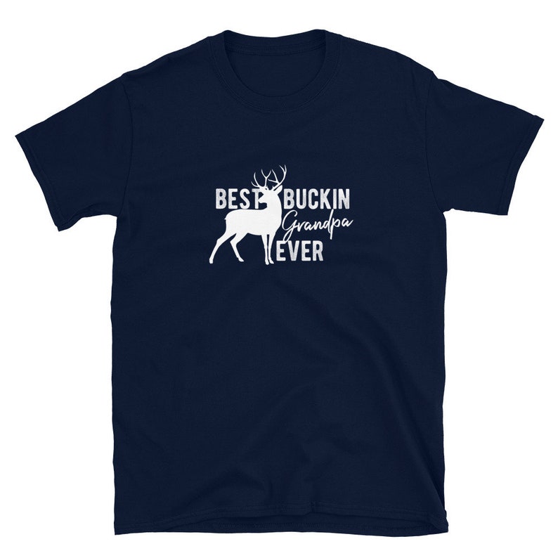 K&ouml;nnte beinhalten: Marineblaues T-Shirt mit einer wei&szlig;en Silhouette eines Hirsches und dem Text "Best Buckin' Grandpa Ever".