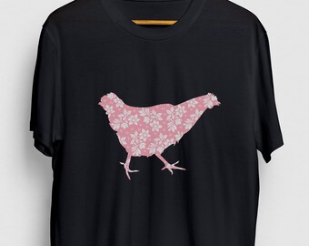 Pode incluir: Camiseta preta com uma silhueta de frango rosa com padrão floral.