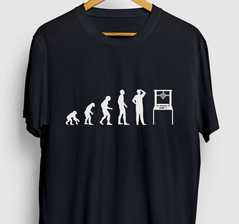 May include: Black t-shirt with a white graphic of the evolution of man ending with a person looking at a 3D printer.