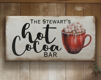 May include: White wooden sign with black text that reads "The Stewart's Hot Cocoa Bar". A red mug with white marshmallows and red and white candy canes is depicted on the sign.