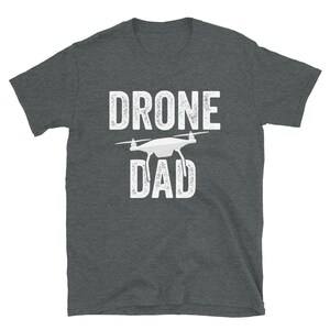 May include: A dark heather grey t-shirt with a white graphic of a drone and the text "DRONE DAD".