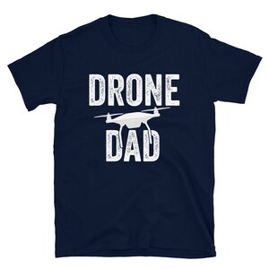 May include: A navy blue t-shirt with white text that reads "Drone Dad" and a white silhouette of a drone.