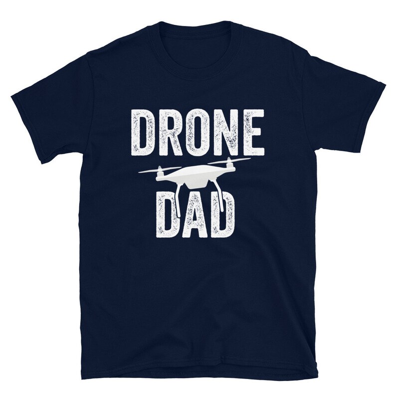May include: A navy blue t-shirt with white text that reads "Drone Dad" and a white silhouette of a drone.