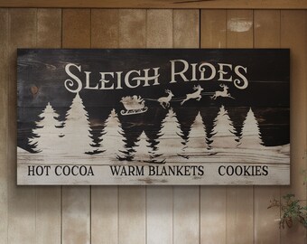 May include: A black wooden sign with white text that reads "Sleigh Rides" with a silhouette of a sleigh pulled by reindeer and a snowy forest scene. The text below the image reads "Hot Cocoa, Warm Blankets, Cookies".