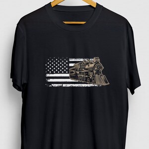 May include: Black t-shirt featuring a vintage-style illustration of a steam locomotive in front of a distressed American flag.