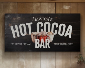 Pode incluir: Uma placa de madeira preta com texto branco que diz "Jessica's Hot Cocoa Bar" com um gráfico de três xícaras de chocolate quente com chantilly e marshmallows. O texto "Whipped Cream" e "Marshmallows" está abaixo das xícaras.
