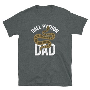 May include: A dark gray t-shirt with a white graphic of a ball python snake and the text "Ball Python Dad".