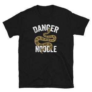 K&ouml;nnte beinhalten: Schwarzes T-Shirt mit einer wei&szlig;en Grafik einer Schlange mit dem aufgedruckten Text "Danger Noodle".