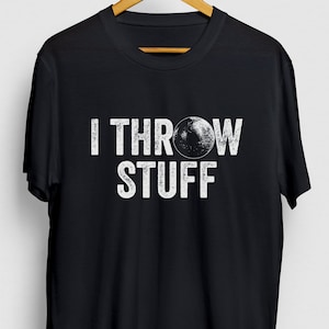May include: Black t-shirt with a white distressed graphic that says "I Throw Stuff" with a white circle representing a disc in the middle of the text.