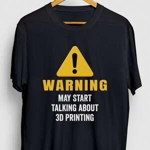 Op de afbeelding: Zwart T-shirt met een geel waarschuwingsbord en de tekst "WARNING MAY START TALKING ABOUT 3D PRINTING".