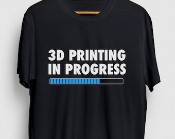 May include: Black t-shirt with white text that reads "3D Printing in Progress" and a blue progress bar.