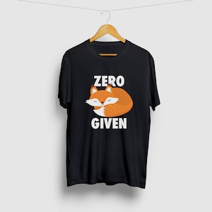 以下が含まれることがあります： 白いフォックスの寝ているグラフィックと「ZERO GIVEN」というテキストが書かれた黒いTシャツ。