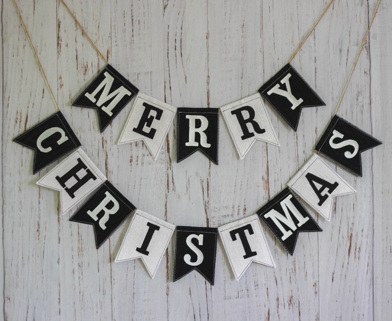 Black and white Merry Christmas fabric banner with alternating flags and matching letters, hanging holiday garland for mantel or fireplace decor.