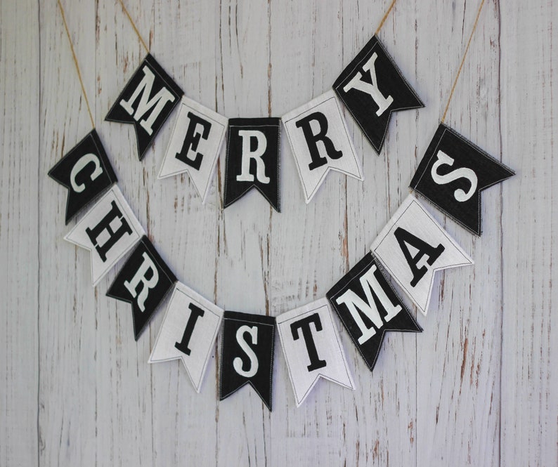 Black and white Merry Christmas fabric banner with alternating flags and matching letters, hanging holiday garland for mantel or fireplace decor.