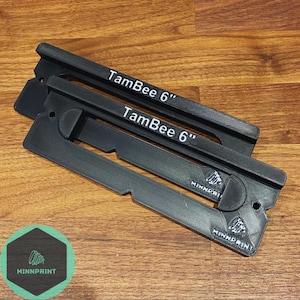 May include: Two black plastic TamBee 6" printer filament holders with the Minnprint logo on the bottom.