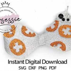May include: A silver glitter bow with orange glitter details, shaped like the character BB-8 from Star Wars. The bow is designed for crafting and includes the text "Instant Digital Download SVG DXF PNG PDF".
